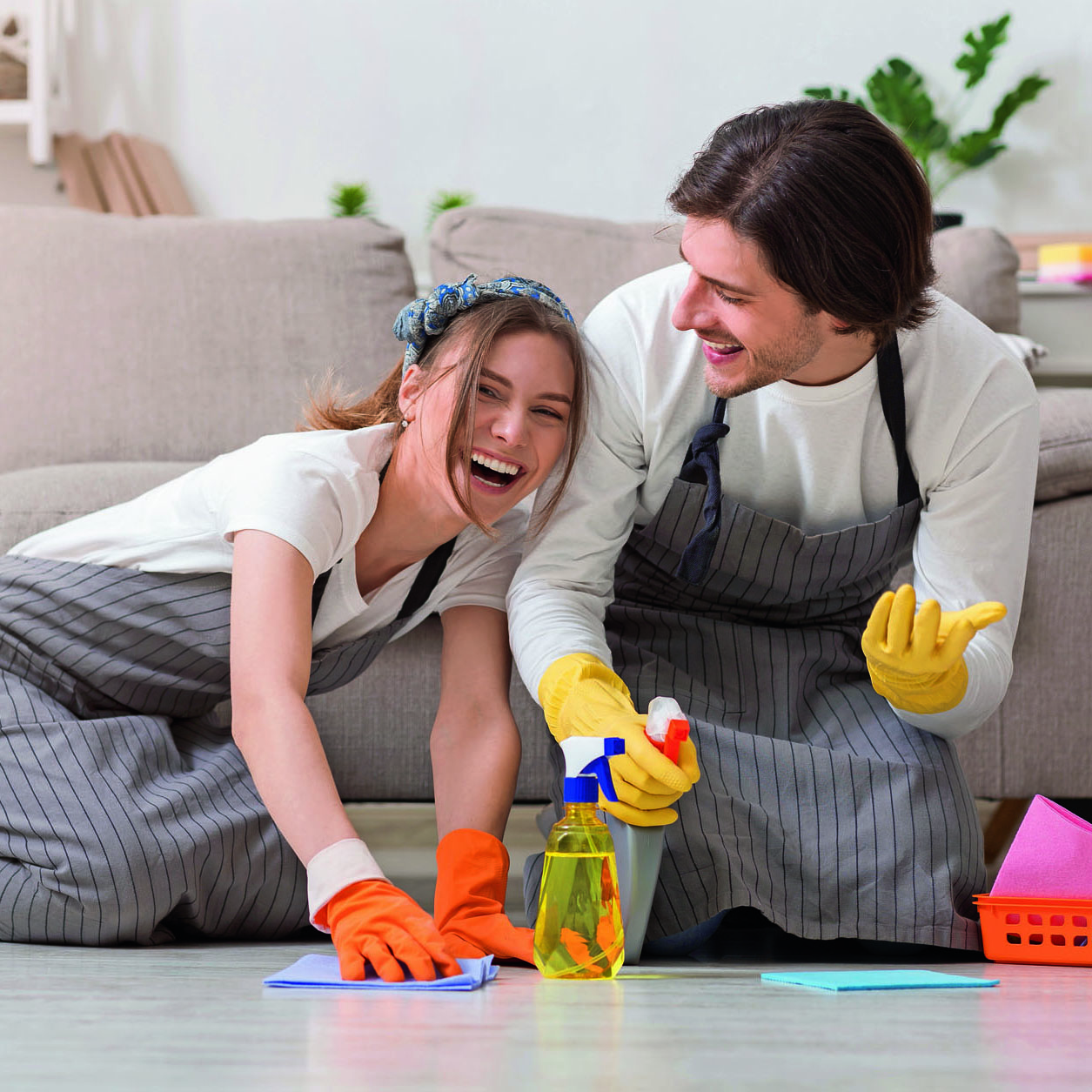 Spring-Clean. Happy Young Couple Having Fun While Cleaning Their House Together, Washing Floor With Spray Detergent And Rag And Sincerely Laughing